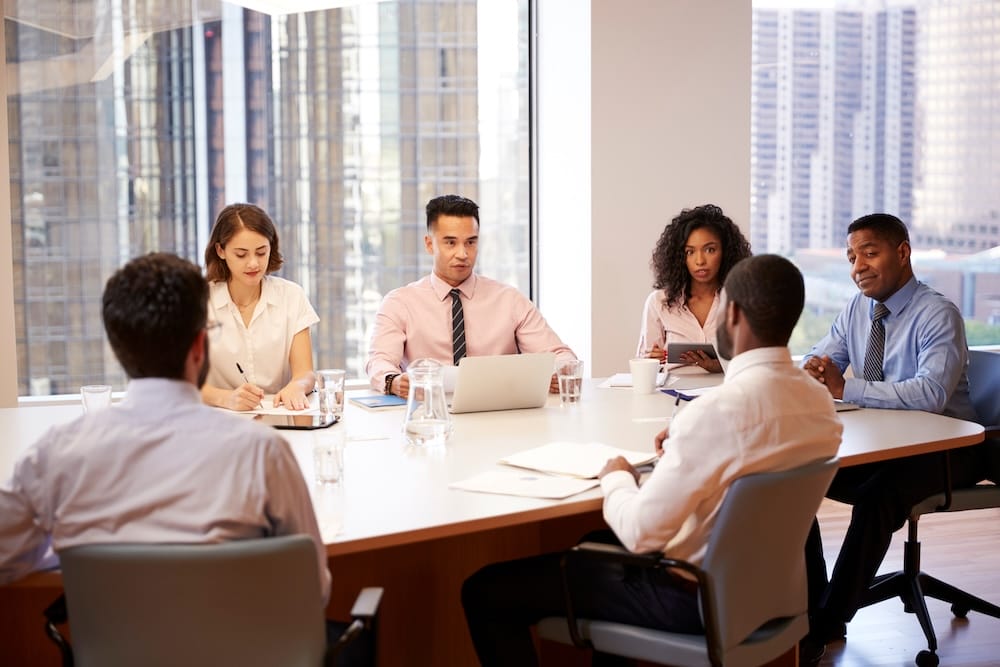 Credit Union staff meeting to discuss payment card solutions for credit unions at a table in an office