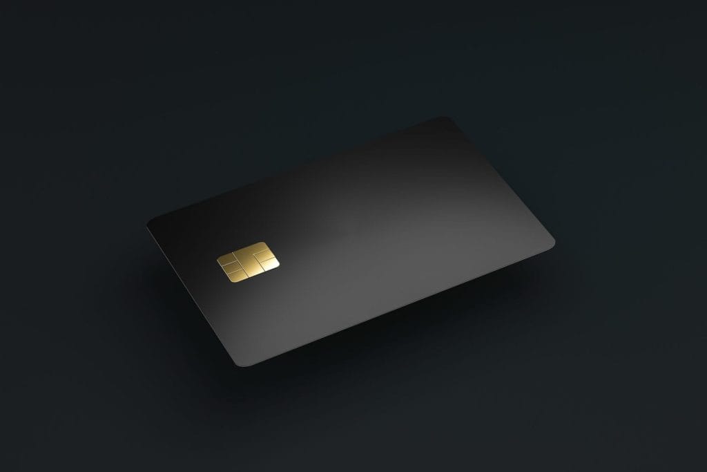 Black EMV chip card hovering on a dark background